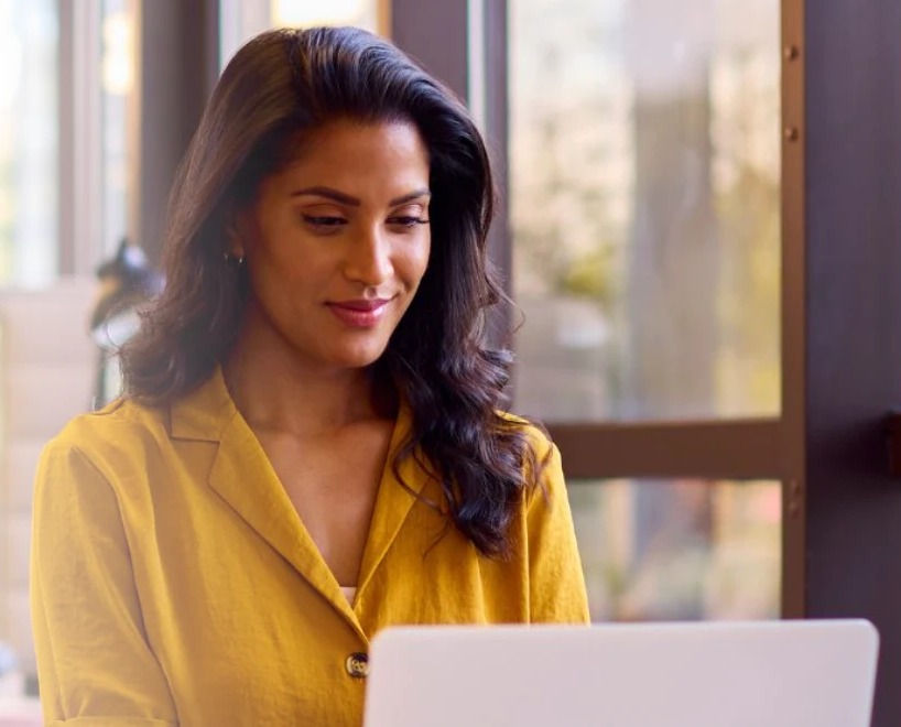 A smiling customer using a laptop in a café