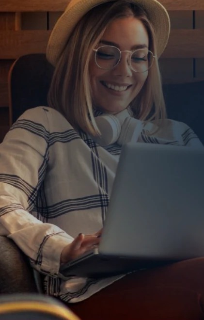 A guest smiling at a laptop in a lounge